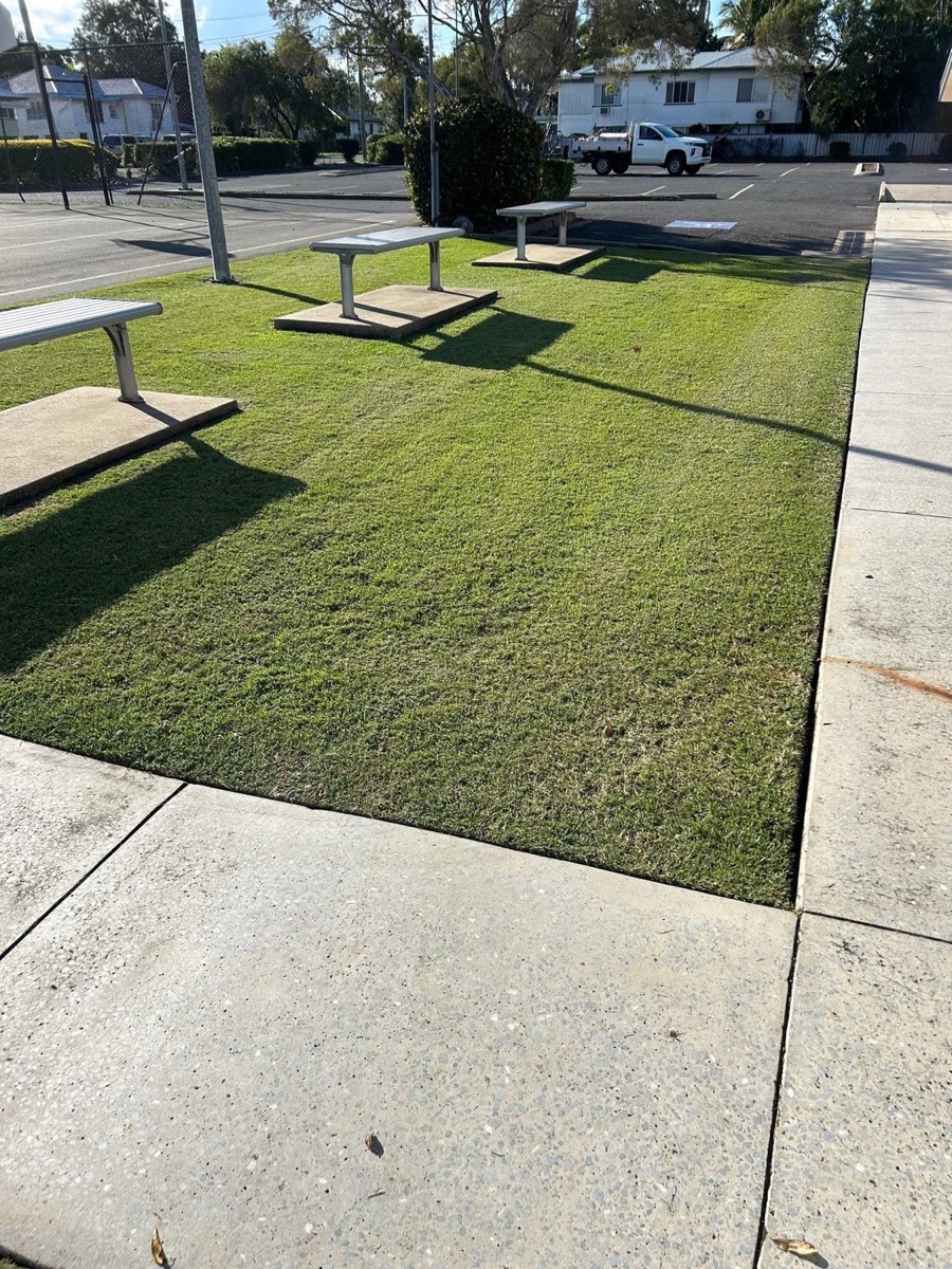Mown grass around picnic tables and a footpath on open grounds
