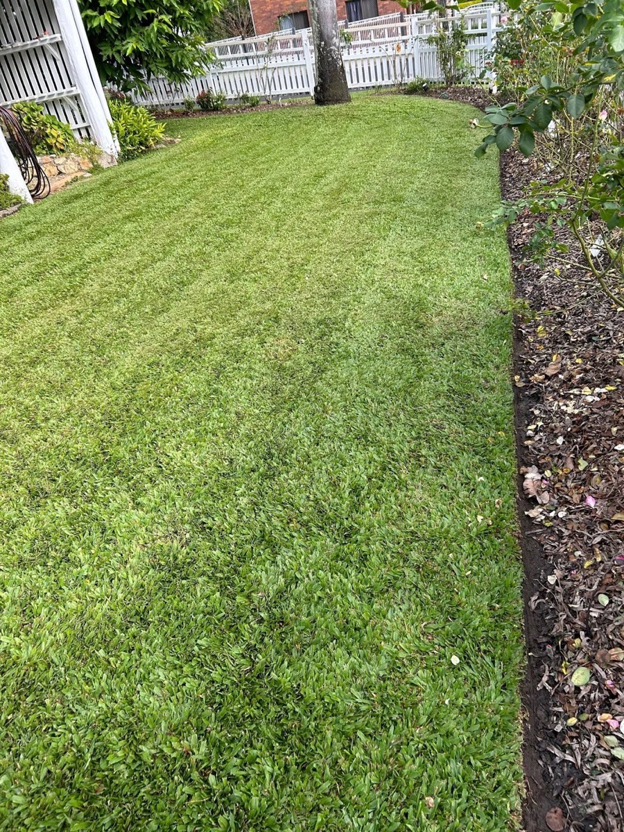 A steep verge cut in even stripes down to the kerb